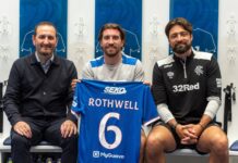 Joe Rothwell holding his Rangers shirt with manager Russell Martin and a club official