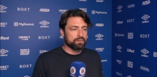 Rangers manager Russell Martin speaking to RangersTV during a media interview in front of the club sponsor wall at Ibrox