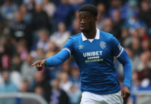 Rangers defender Emmanuel Fernandez in action during a pre-season friendly match, wearing the blue home kit and pointing.