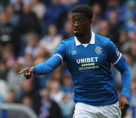 Rangers defender Emmanuel Fernandez in action during a pre-season friendly match, wearing the blue home kit and pointing.