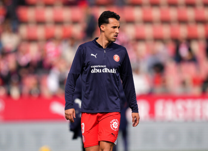Bojan Miovski warming up in a Girona FC training top during a La Liga match.
