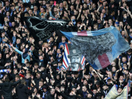 Rangers supporters waving large flags and cheering during a match against Viktoria Plzen in the UEFA Champions League qualifiers.