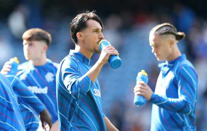 Rangers v Celtic - William Hill Premiership Bojan Miovski takes a drink from a blue water bottle during Rangers warm-up at Ibrox, with team-mates beside him in training kit.
