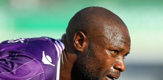 Former Chelsea defender William Gallas in action, wearing a purple kit and sweating during a match.