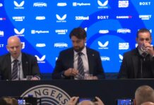 Patrick Stewart, Russell Martin, and Kevin Thelwell at a Rangers press conference table in front of a blue sponsor backdrop