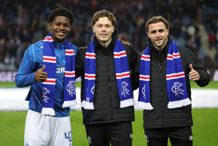 Andreas Skov Olsen Tochi Chukwuani and Tuur Rommens pose with Rangers scarves on the Ibrox pitch before kick off