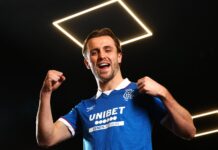 Tuur Rommens celebrates signing for Rangers in the official club kit