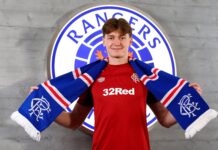 Ryan Naderi holding a Rangers scarf during his official signing photo at Ibrox