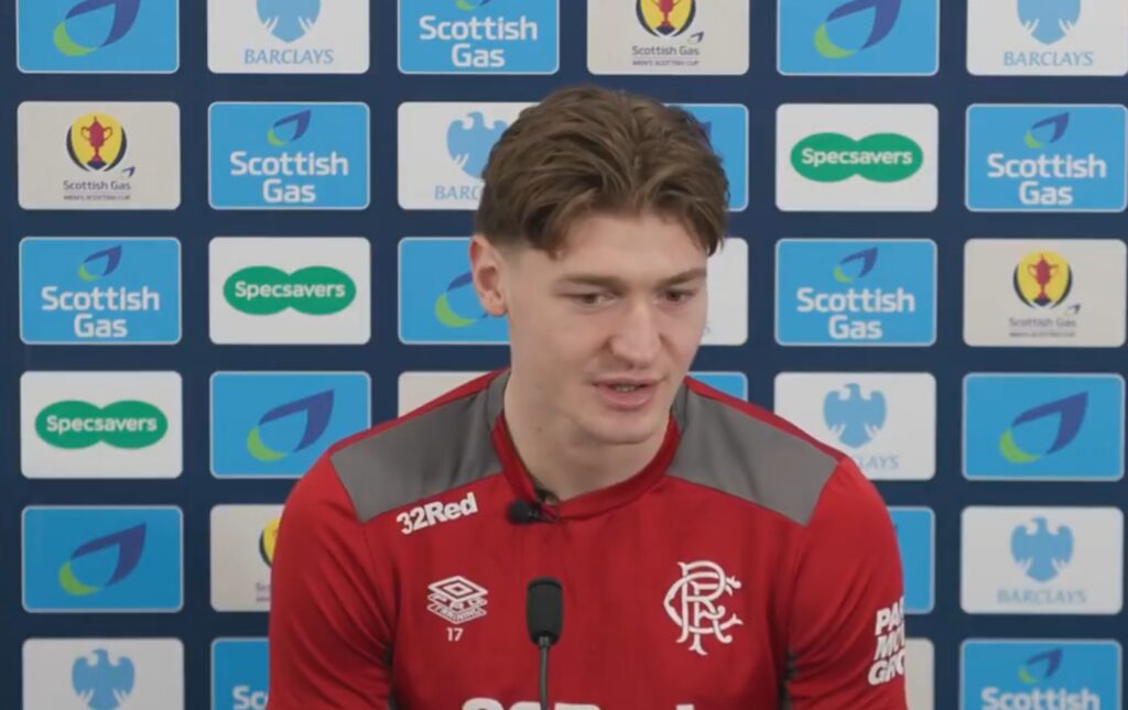 Ryan Naderi speaking to the media at a Rangers press conference with Scottish Gas backdrop