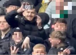 Celtic supporter holding 66 sign during Old Firm match at Ibrox